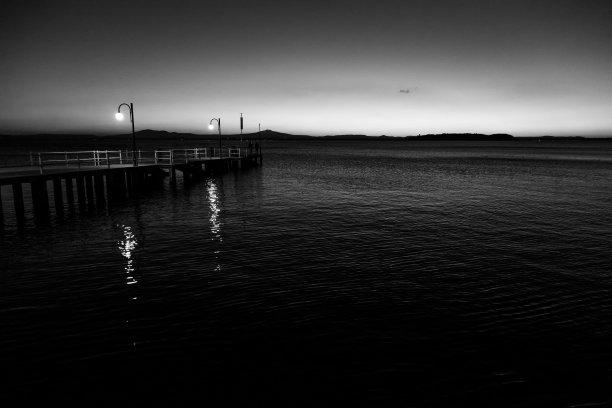 黄昏时分，意大利翁布里亚(Umbria)的特拉西梅诺湖(trasiimeno)码头上的一些人图片下载