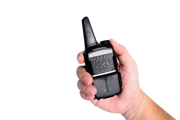 拿着无线电收发机或对讲机的人的手。在白色背景或孤立图片下载