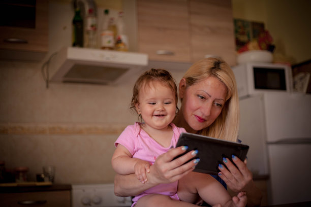母亲和女儿看平板电脑。图片下载