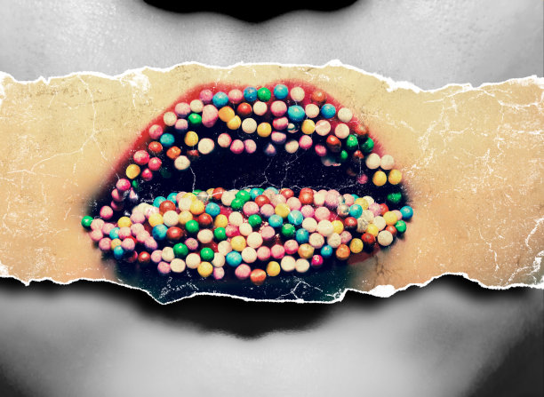 女性的嘴唇用红色的口红和彩色的糖果在嘴唇上特写。彩色照片与旧纸张的效果在同一黑白照片的背景。图片下载