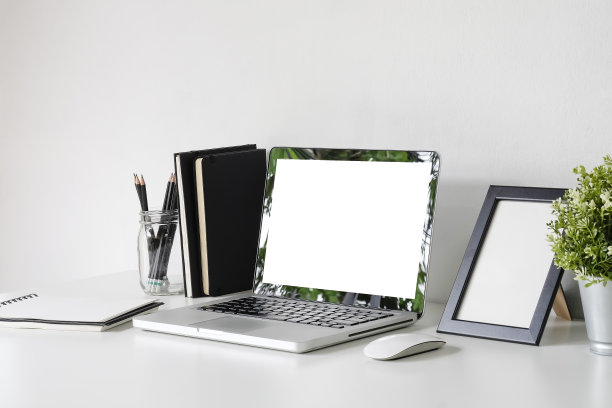 原型笔记本电脑在工作空间，相框，罐子的铅笔，鼠标和笔记本纸在办公桌上。图片下载