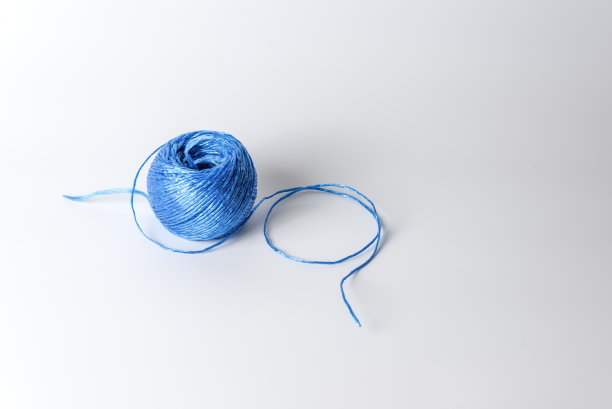 白色背景上缠绕的蓝色绳子。近距离图片下载