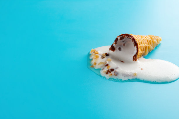 蓝色背景上正在融化的迷你香草味冰淇淋蛋卷图片下载