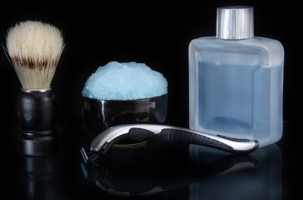 剃须配件。玻璃桌子与反射。黑色背景。图片下载