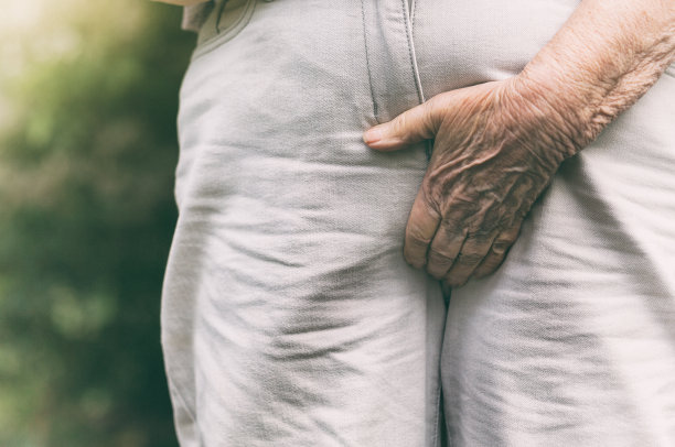 老年妇女的手抓住腹股沟，以防止不自主的尿失禁图片下载