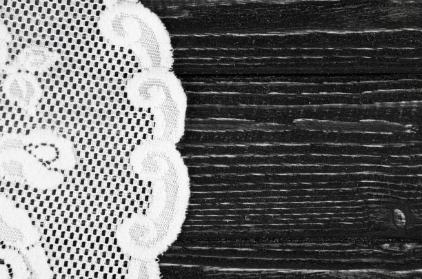 白色蕾丝餐巾上的黑色木制背景与copyspace在右边图片下载