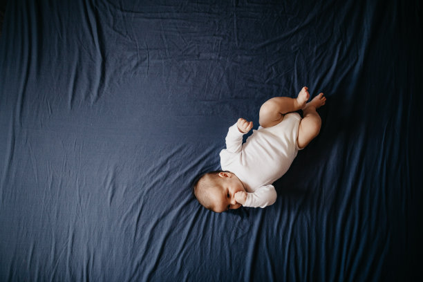 两个月大的婴儿躺在床上图片下载