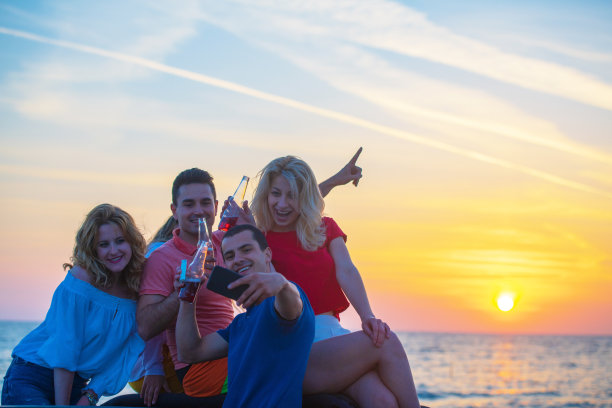 日落时分，五个年轻人在海滩上开敞篷车玩。图片下载