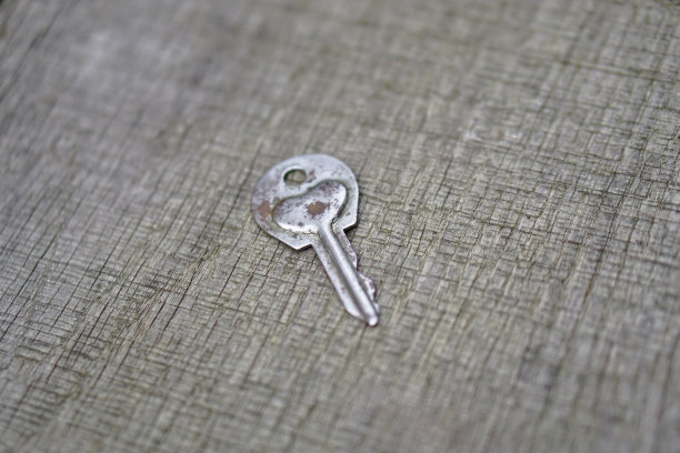 情人节或婚礼的浪漫背景。一把旧钥匙，在一块旧木板上刻着一颗心。设计素材照片图片下载