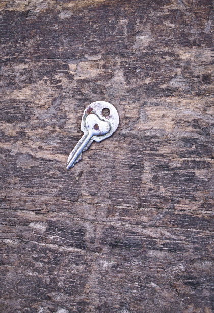 情人节或婚礼的浪漫背景。一把旧钥匙，在一块旧木板上刻着一颗心。设计素材照片图片下载