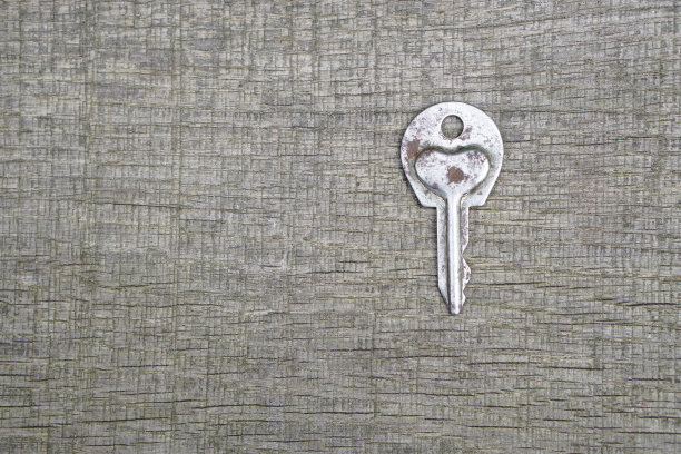 情人节或婚礼的浪漫背景。一把旧钥匙，在一块旧木板上刻着一颗心。设计素材照片图片下载