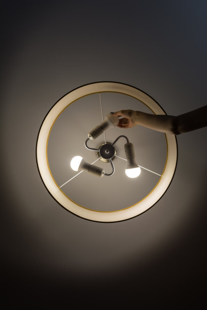 女手拧节能，LED灯泡在天花板下的吊灯。图片下载