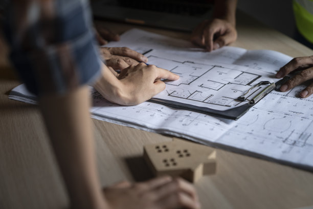 女土木建筑师与工程师讨论建筑规划，工程和建筑概念。蓝图是伪造的，只用于库存照片。图片下载