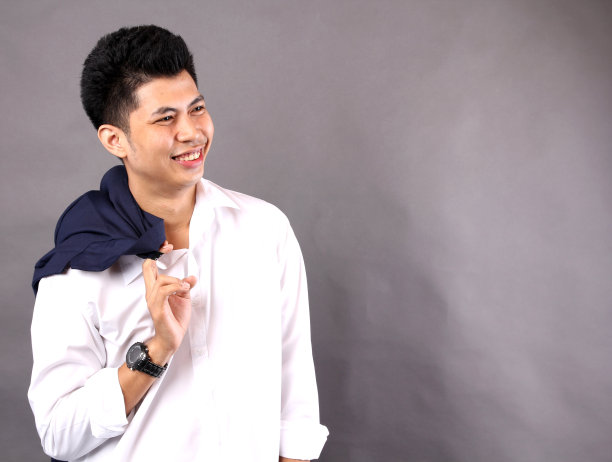 亚洲人对着白色背景微笑。图片下载