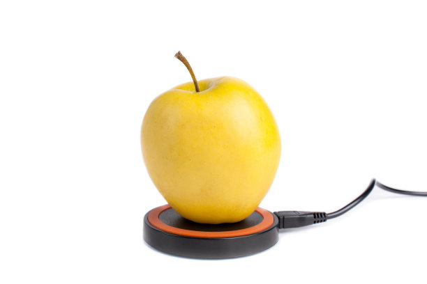 黄色苹果放置在一个平台上，在一个孤立的白色背景下进行无线充电图片下载