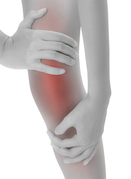 女人抱着她美丽健康的长腿按摩膝盖疼痛区黑白颜色，红色突出，孤立在白色背景。图片下载
