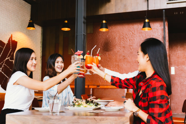 一群亚洲快乐和微笑的年轻男子和妇女拿着酒精鸡尾酒祝酒和庆祝在社交聚会在餐厅ใ素材图片