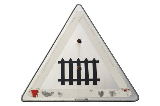 老旧褪色生锈的路标“有守卫的铁路道口”孤立在白色上。图片下载