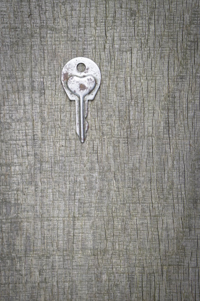 情人节或婚礼的浪漫背景。一把旧钥匙，在一块旧木板上刻着一颗心。设计素材照片图片下载
