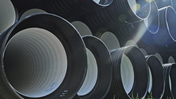 成品塑料管仓库，工业户外储存场地。生产塑料水管的工厂。图片下载