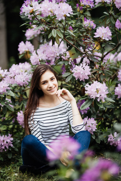 紫色背景上的漂亮年轻女子。带着紫色花朵的美女图片下载