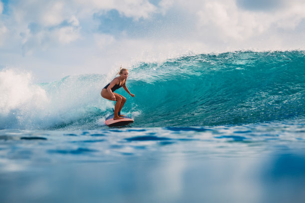 迷人的女人在冲浪板上。冲浪者和海浪图片下载