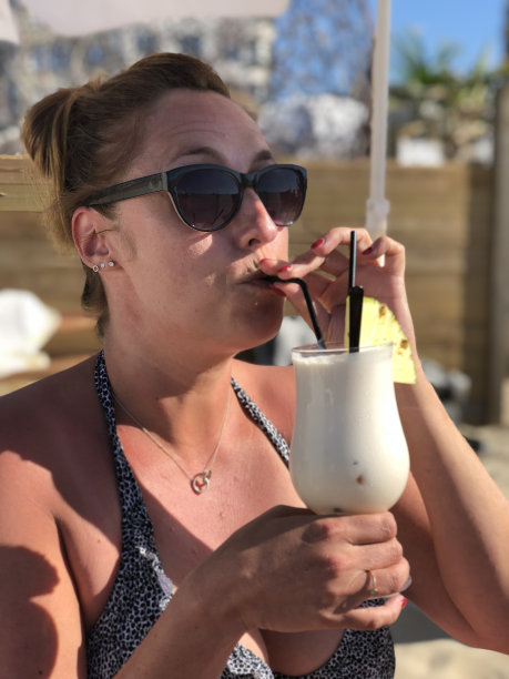 在欧洲的一个海滩俱乐部里喝着鸡尾酒的女人图片下载