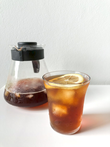 加了一片柠檬的冰咖啡。服务员在后面端咖啡。图片下载