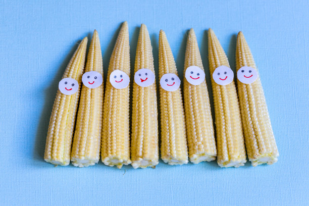 小玉米长着滑稽的脸。健康的有机食品。图片下载