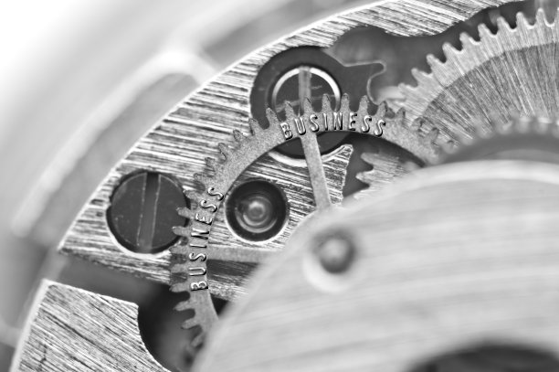 背景与铭文业务。黑白色背景与金属齿轮发条。宏。概念性照片为您成功的业务设计。金属黑白字母，齿轮。团队合作理念图片下载