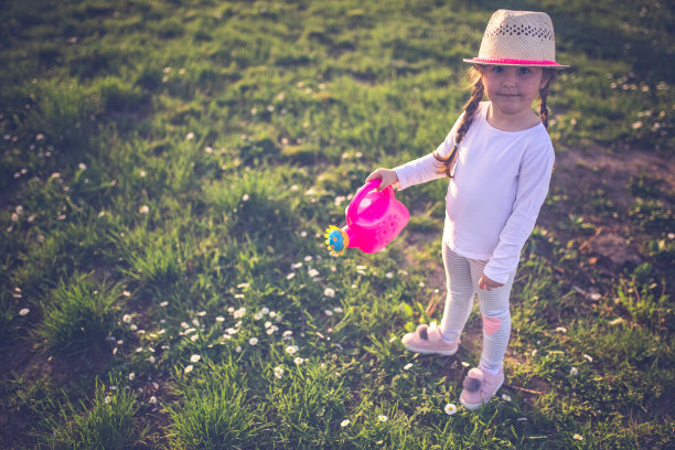可爱的小孩戴着帽子浇花图片下载