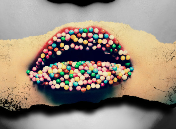 女性的嘴唇用红色的口红和彩色的糖果在嘴唇上特写。彩色照片与旧纸张的效果在同一黑白照片的背景。图片下载