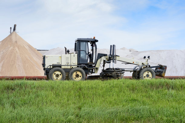 分级机位于矿山背景有管道的大坝处。侧视图。前景绿草图片下载
