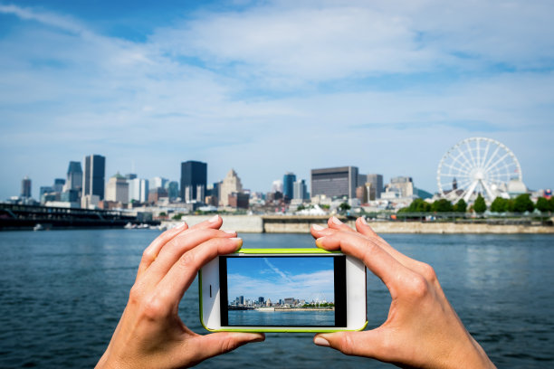 一个女人在河边拍城市的照片图片下载
