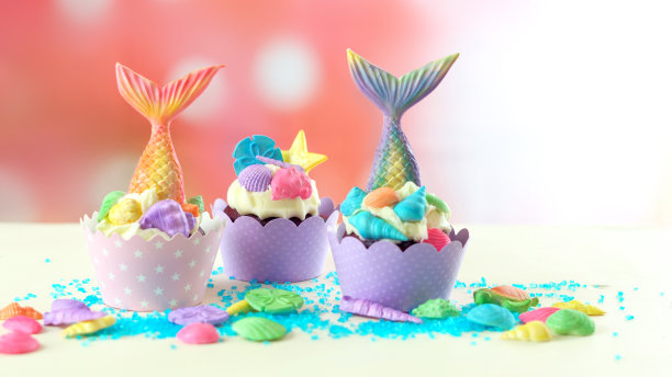 美人鱼主题的纸杯蛋糕有五颜六色的闪闪发光的尾巴，贝壳和海洋生物图片下载