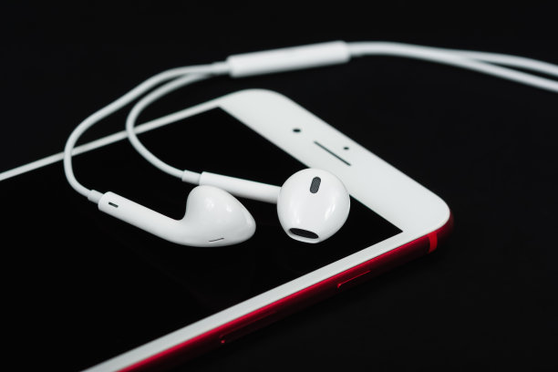 黑色背景下的耳机和智能手机。顶部视图与复制空间。音乐的概念图片下载