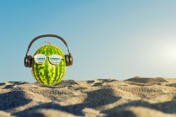 创意和夏天的照片西瓜的形状的人的头在眼镜在沙滩上的沙子。图片下载