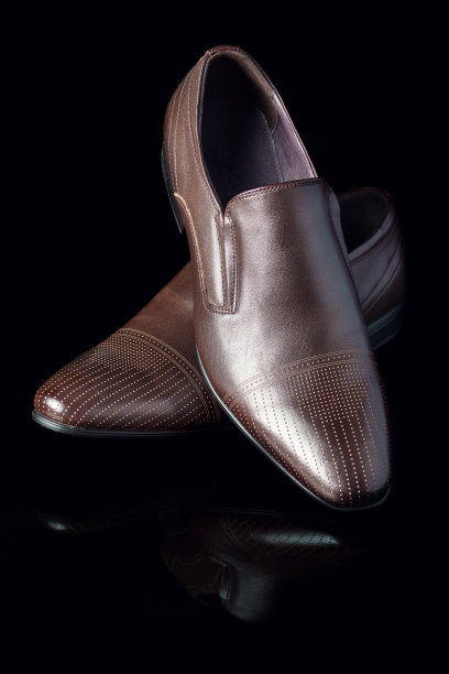 棕色男人的鞋子在黑色光滑的背景上图片下载