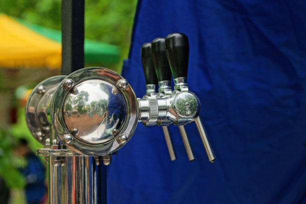 街上公园酒吧里装啤酒用的灰色铁龙头图片下载