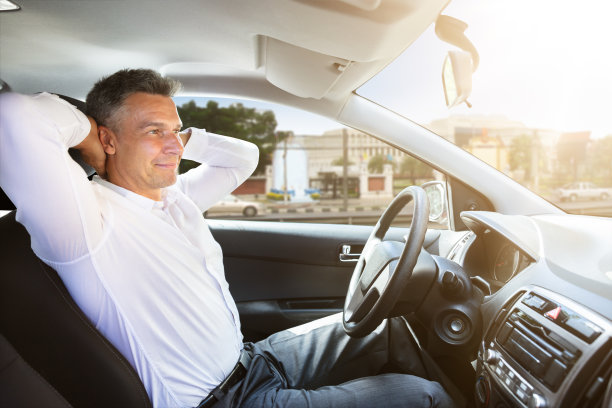 放松的男人坐在自动驾驶汽车里素材图片