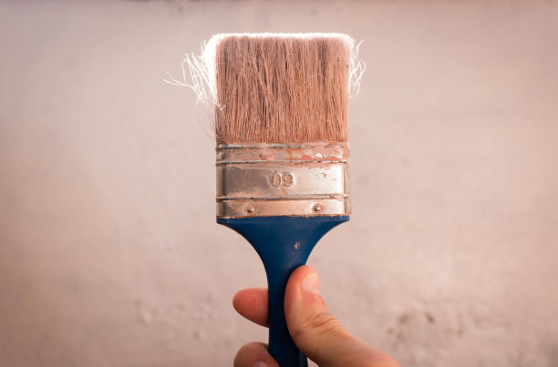 手拿刷子刷墙。修复图片下载