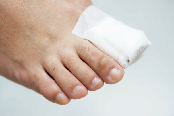 白色背景上缠着纱布的大脚趾甲图片下载