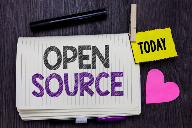 显示开源的文本符号。概念照片表示软件，原始源代码免费提供打开笔记本晾衣夹，保持提醒标记心木制背景。图片下载