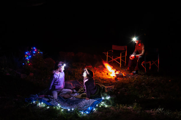 父亲和两个女儿坐在篝火旁图片下载