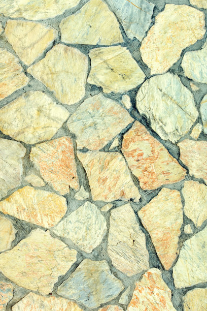 大石头的背景。由不平的鹅卵石制成的马赛克。美丽的照片与石材纹理。图片下载