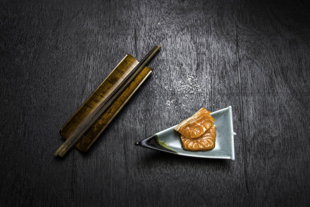 黑色背景的三文鱼生鱼片图片下载