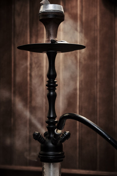 烟雾中的水烟在模糊的木制背景上的特写。图片下载