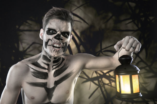 年轻时尚的男人与艺术格林为万圣节派对。时尚的人体艺术。面对艺术图片下载