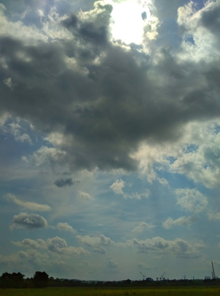 绿色草坪上的天空中白云。垂直的照片。图片下载