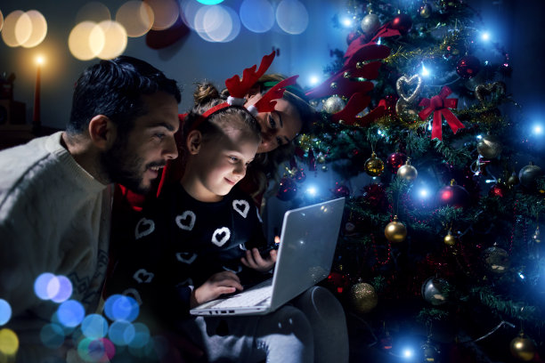 圣诞节的晚上，一家人共用一台笔记本电脑图片下载